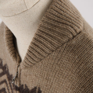 Close-up of a brown knitted sweater with a patterned design on a neutral background