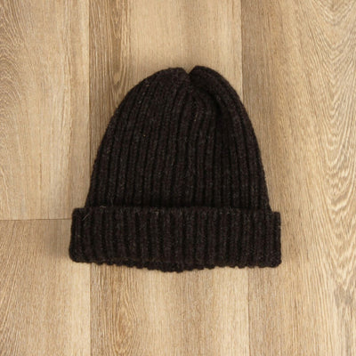 Black knit beanie on a wooden surface
