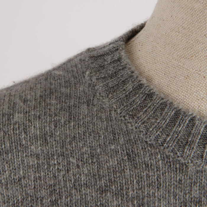 Close-up of a gray knitted sweater collar on a neutral background