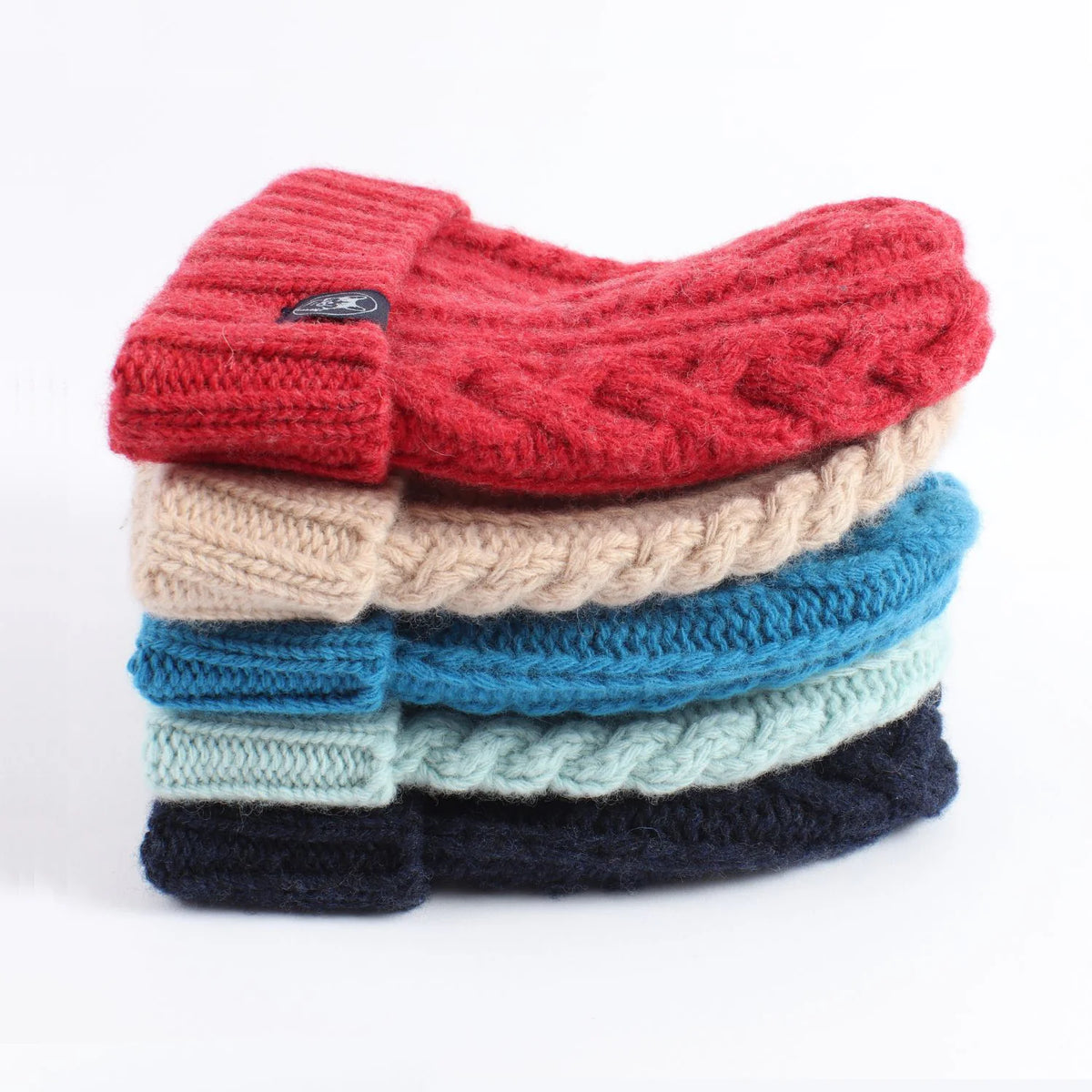 Stack of colourful knitted scarves on a white background