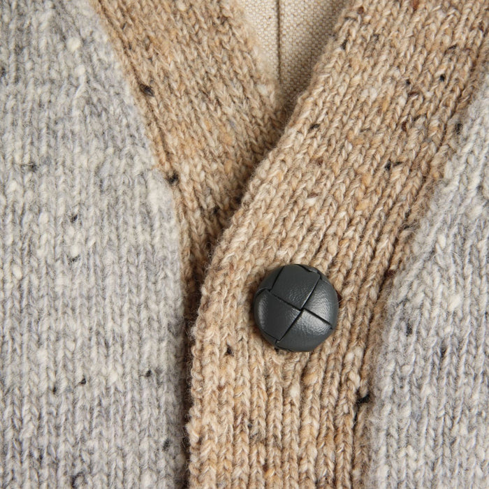 Close-up of a textured fabric with a grey leather button