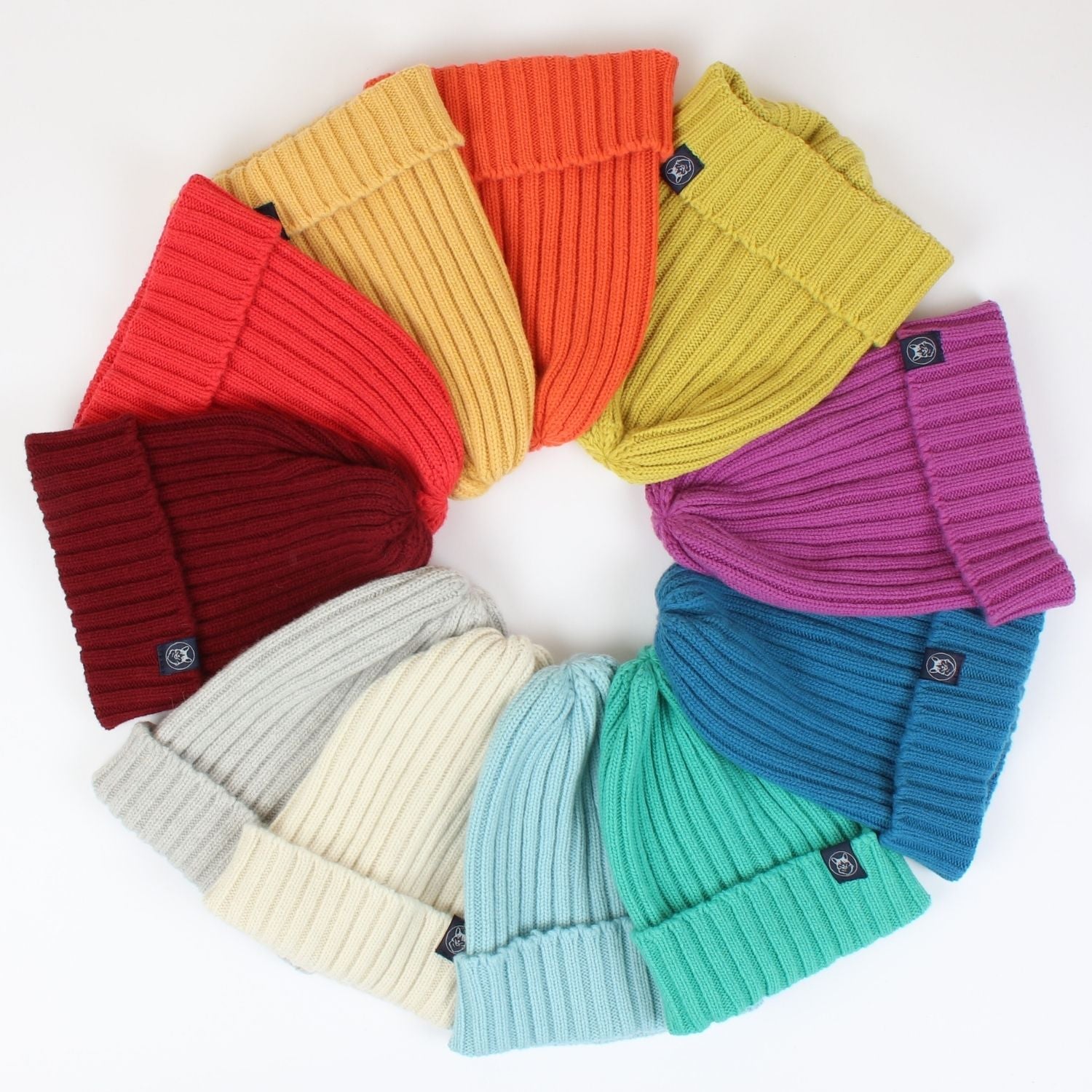 A collection of women's ribbed wool beanies in various colors displayed in a circular pattern.