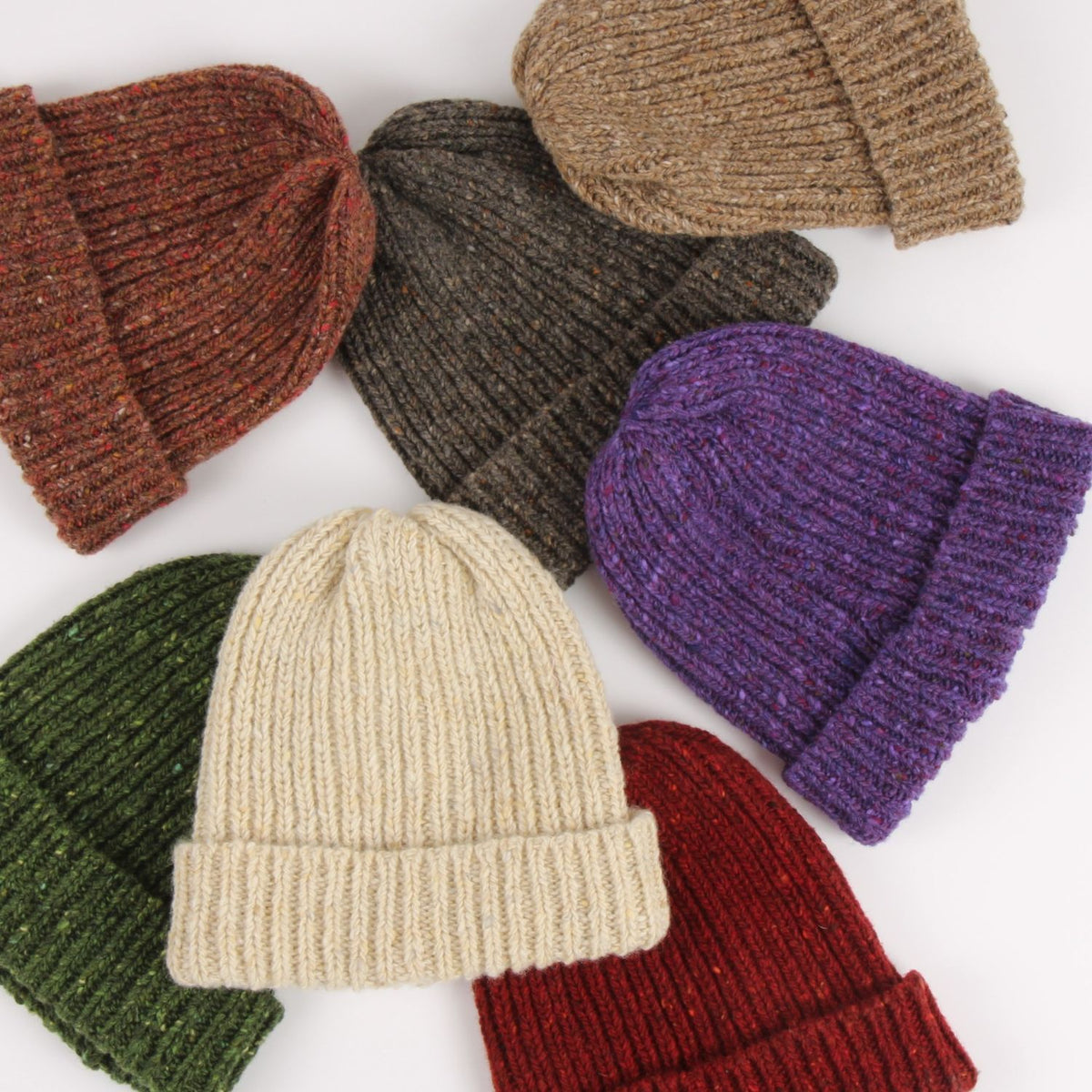 Collection of knit hats in various colors on a white background