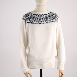 White sweater with navy pattern on neckline on a mannequin against a white background
