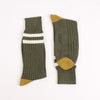 Pair of green socks with two white striped and  mustard yellow accents on the heel and toe, photographed on a white background