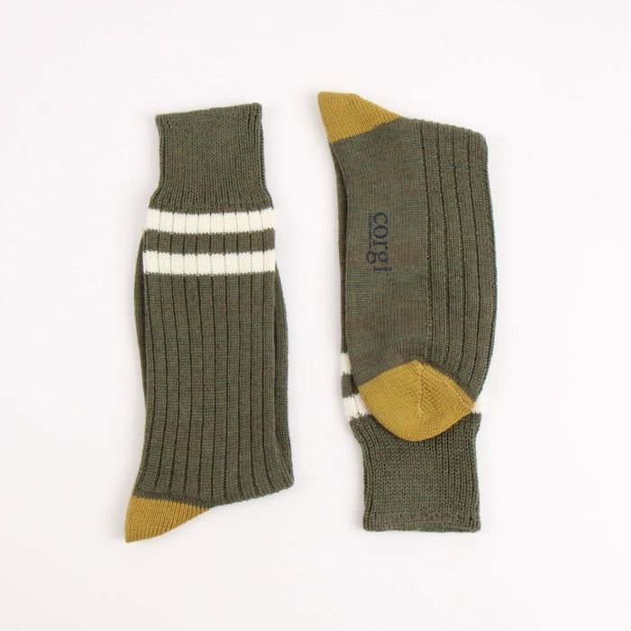 Pair of green socks with two white striped and  mustard yellow accents on the heel and toe, photographed on a white background