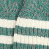Close-up of a knitted sock made in a green and grey twist with two white stripes.