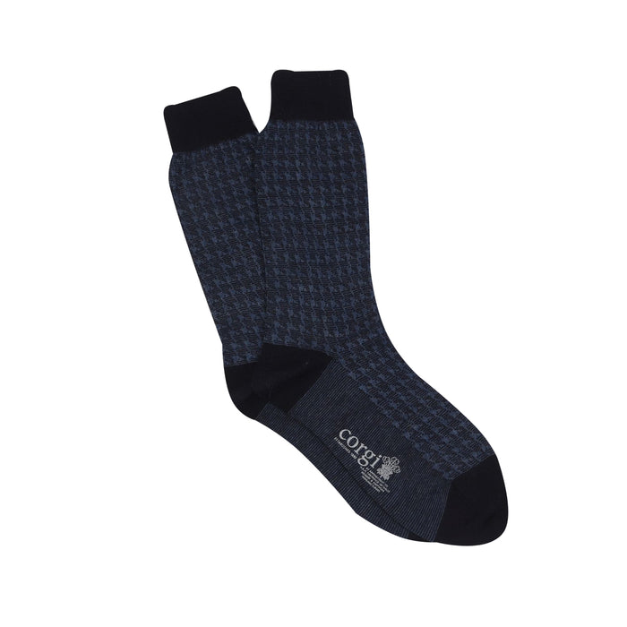 A pair of men's formal houndstooth merino wool socks in blue, showing the pattern and texture,