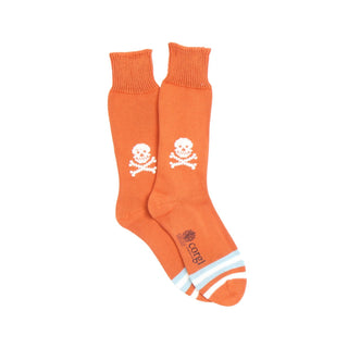Orange socks with skull and crossbones design on a white background