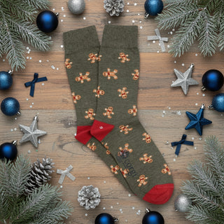 Loden green socks with gingerbread man patterns and red heel and toes on a white background