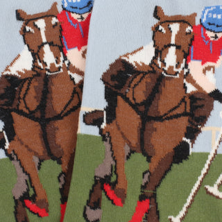 Horses and jockeys in a race with a blue sky background