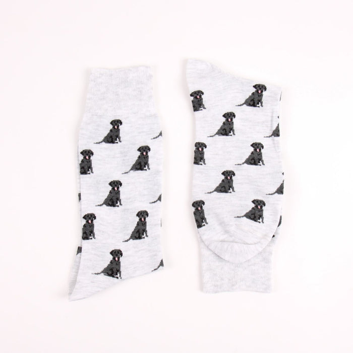 Two grey socks with black labrador retriever pattern on a white background