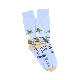 Light blue sock with palm tree and building design on a white background