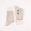 Pair of silver socks with cable knit pattern on a white background