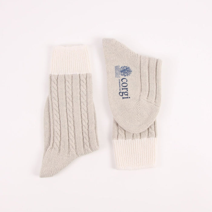 Pair of silver socks with cable knit pattern on a white background