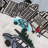 A pair of women's socks with a Christmas in the city scene design, featuring a snow-covered street, buildings, and decorative elements.