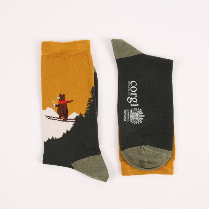 Two socks with skiing bear designs on a white background
