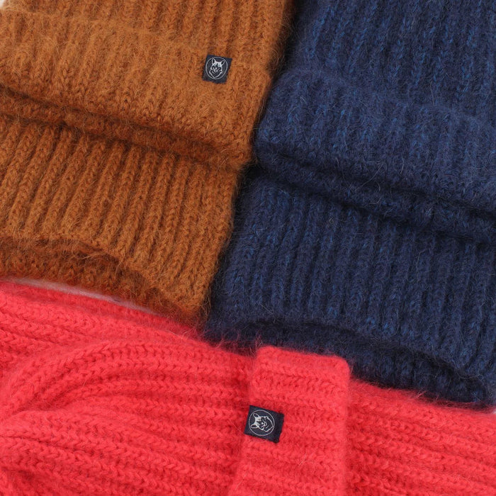 Stack of brown, blue, and red knitted sweaters with brand logos.