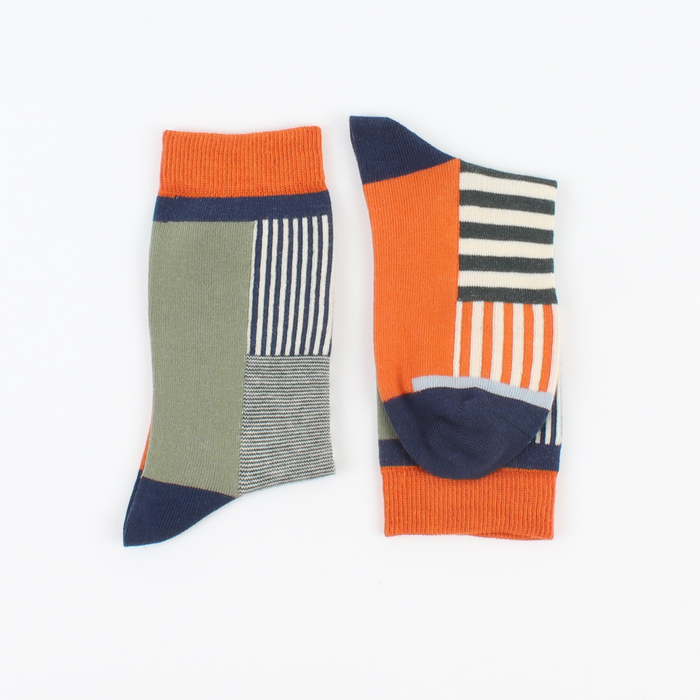 A pair of socks with a colourful geometric pattern, featuring orange, green, and navy stripes