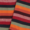 Close-up of striped fabric with red, green, orange, and black colors.