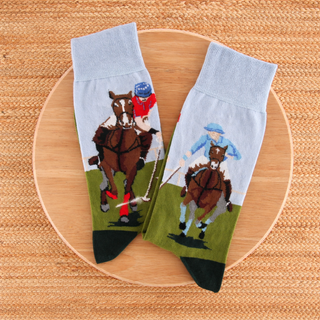 Two socks with horse and rider design on a wooden surface