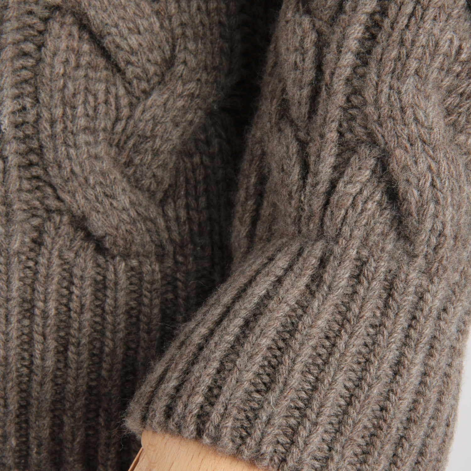 Close-up of a brown knitted sweater with cable pattern