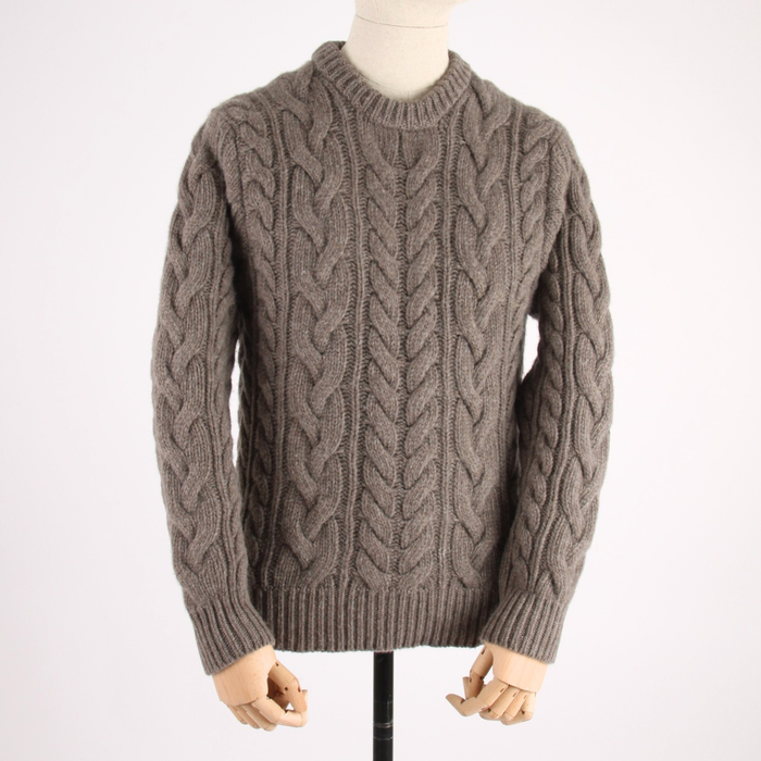 Brown cable knit sweater on a mannequin against a white background