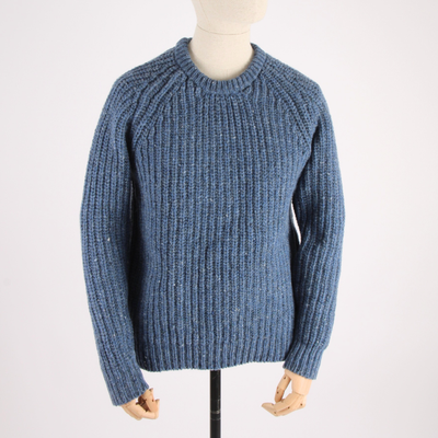 Blue knitted sweater on a mannequin against a white background