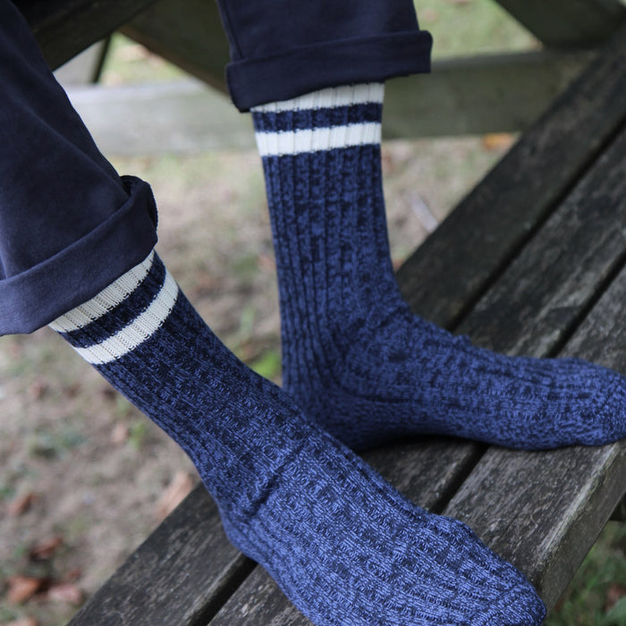 Blue marl pure cotton knitted socks with white stripes on a wooden bench
