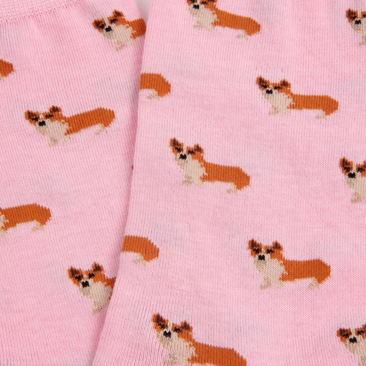 Pink knit fabric with an allover pattern of small corgi dog illustrations in orange, white, and black.