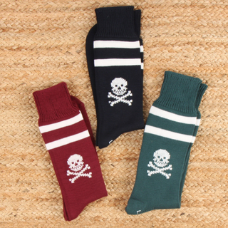 Three socks with skull and crossbones design on a textured surface