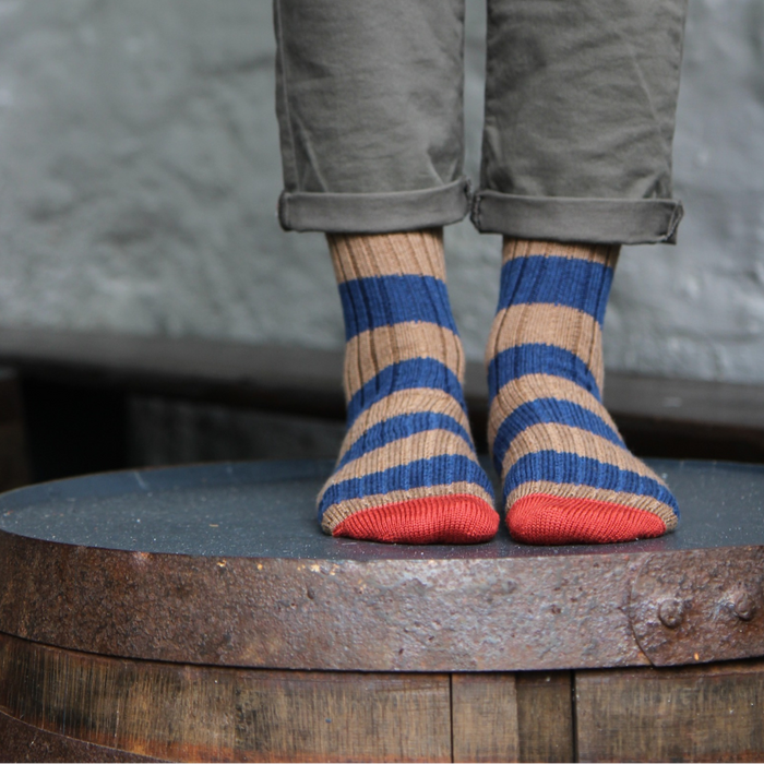 Person wearing striped socks with a rustic background