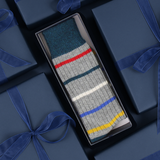 Striped sock in a box with blue ribbons on a matching background