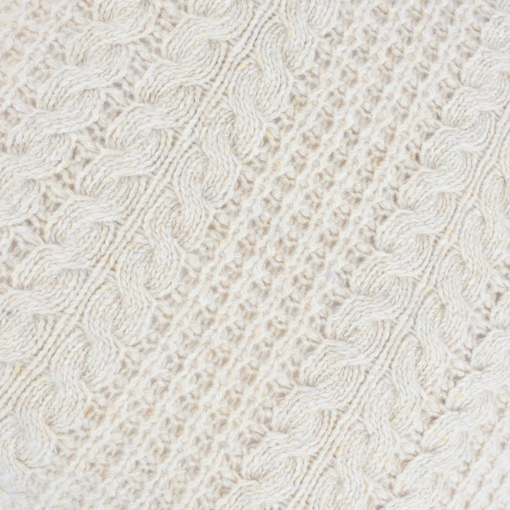 Close-up of a textured white fabric with a cable knit pattern