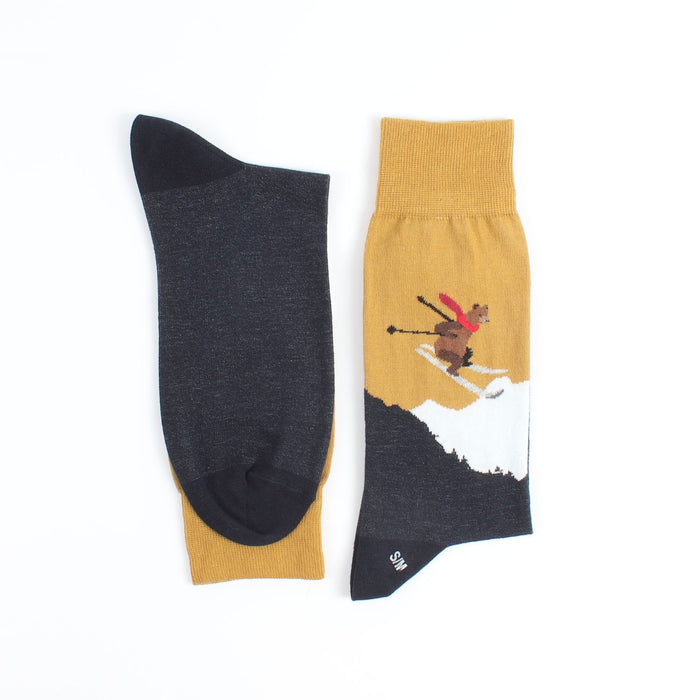 A pair of men's socks with a Christmas-themed design featuring a skiing bear
