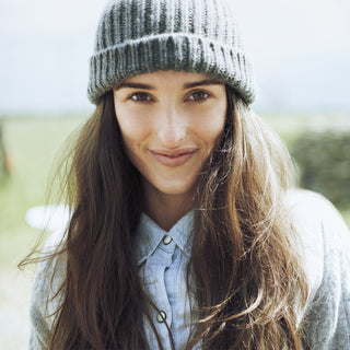 Woman wearing a knit hat with a blurred natural background