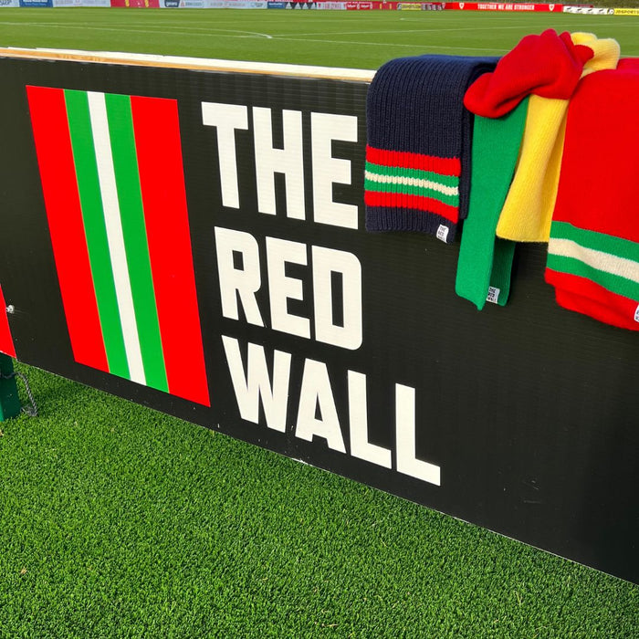 Collection of scarves on the football stand with The Red Wall logo.