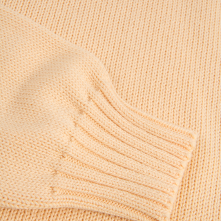 Close-up of a yellow knitted fabric with a ribbed texture.