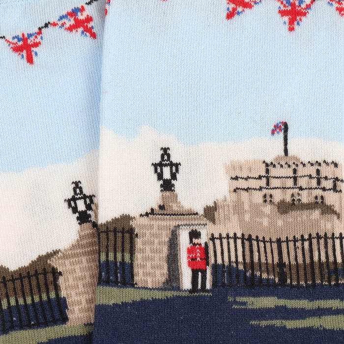 A close up of a pair of men's socks with a detailed illustration of Windsor Castle, featuring a predominantly white cuff with a red ribbon design, a blue shaft, and red heel.