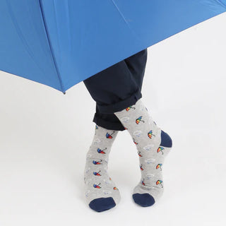 Person wearing rain cloud and umbrella patterned socks with a blue umbrella