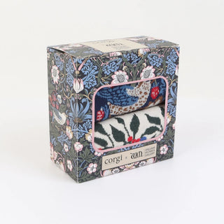 Floral-patterned box containing a knitted item with 'corgi' branding on a white background