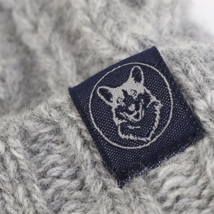 Navy blue label with a logo on a textured grey fabric background