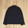 flat image of a navy roll neck pullover on a wooden floor