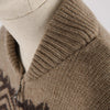 Close-up of a brown knitted sweater with a patterned design on a neutral background

