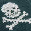 Close-up of a knitted pattern with white yarn on a dark green fabric background