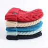 Stack of colourful knitted scarves on a white background