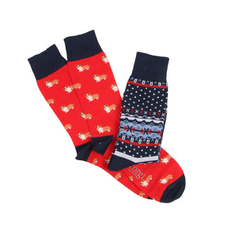 Two pairs of socks with different patterns , one pair with corgi dogs the other a traditional fairisle design photographed on a white background