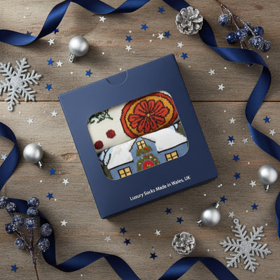 Box of luxury socks with Christmas designs on a white background