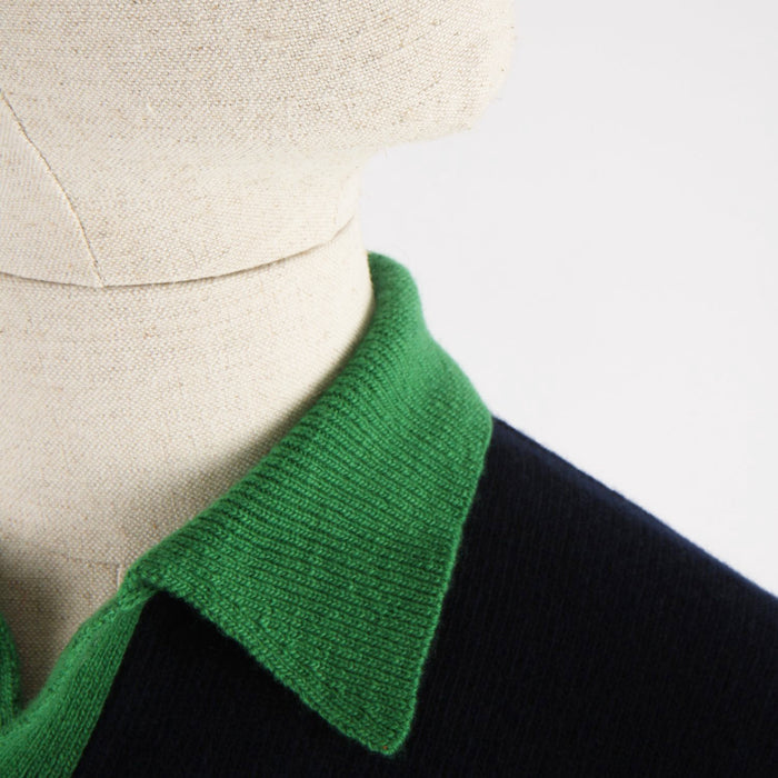 Close-up of a green collar on a black garment with a neutral background

