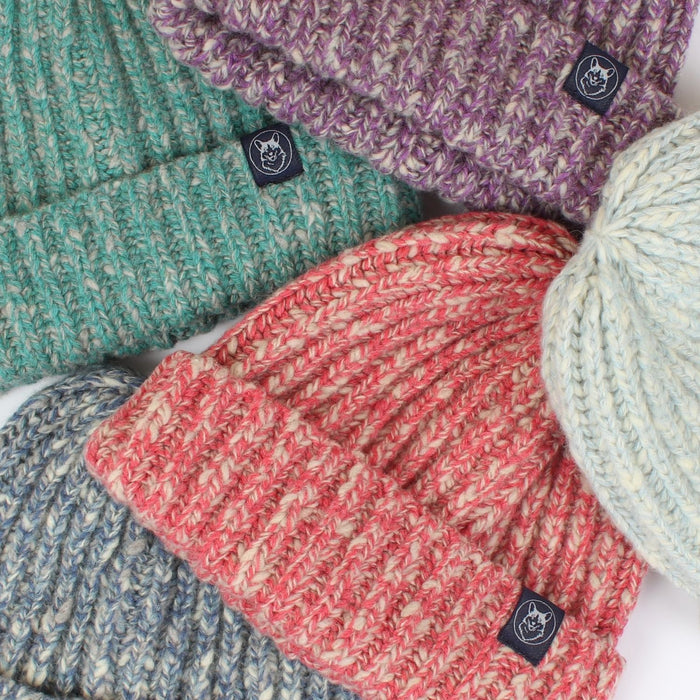 colourful beanies laid flat on a white background.